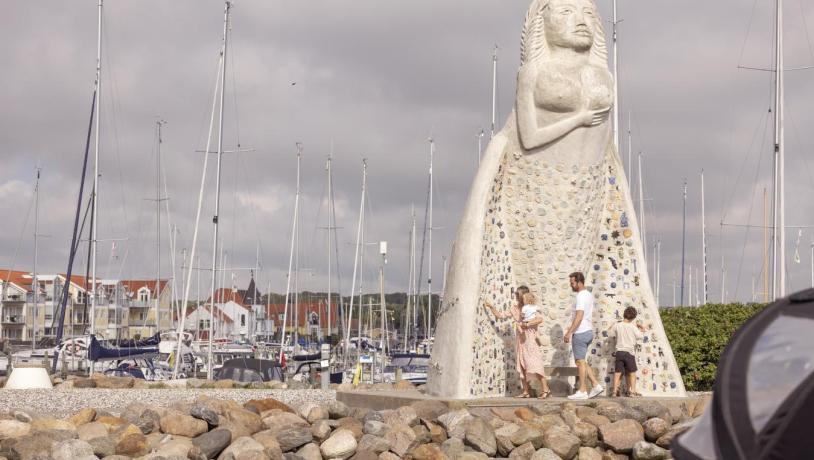 Sæby Havn med familie foran 7 meter høje statue, fruen fra havet