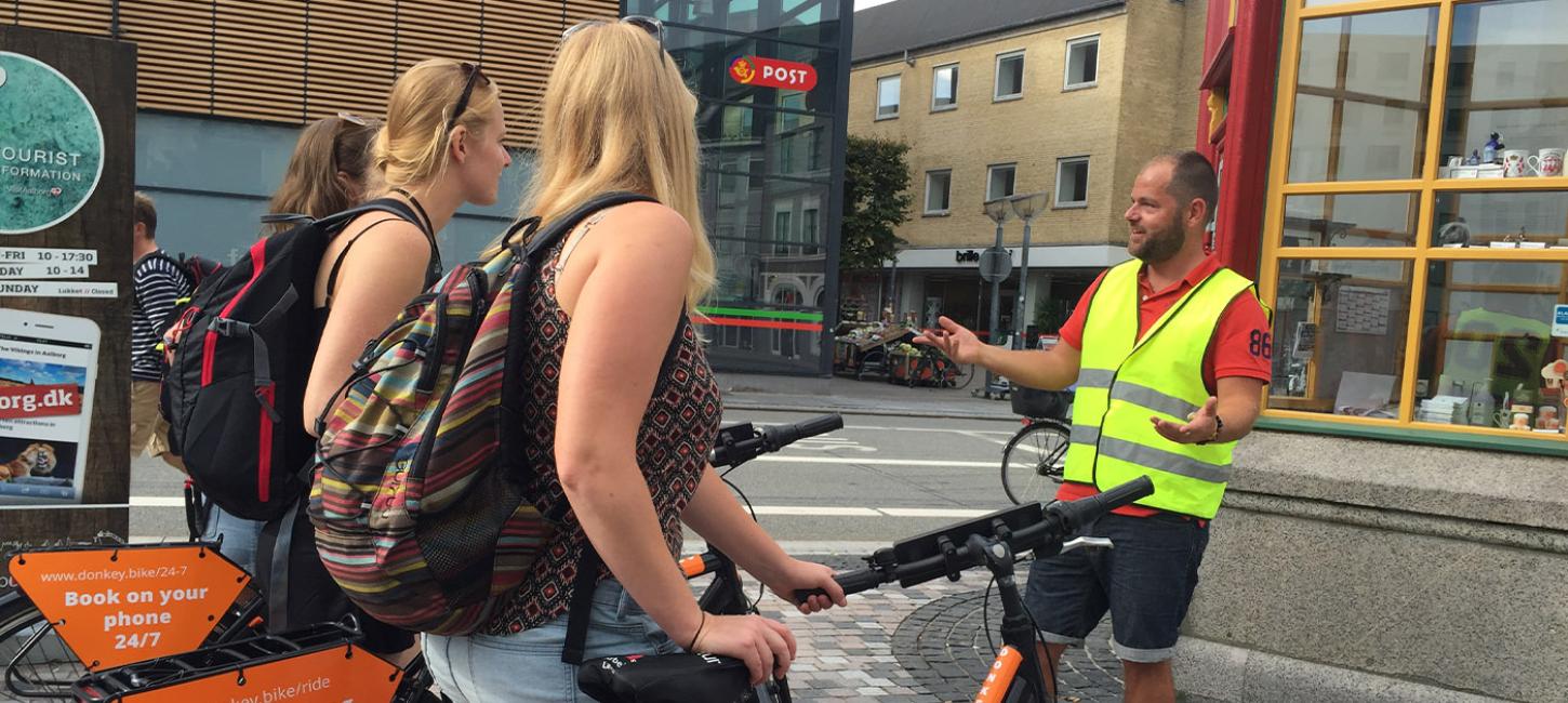 Gruppe med cykler får guided tur på Gabels Torv i Aalborg