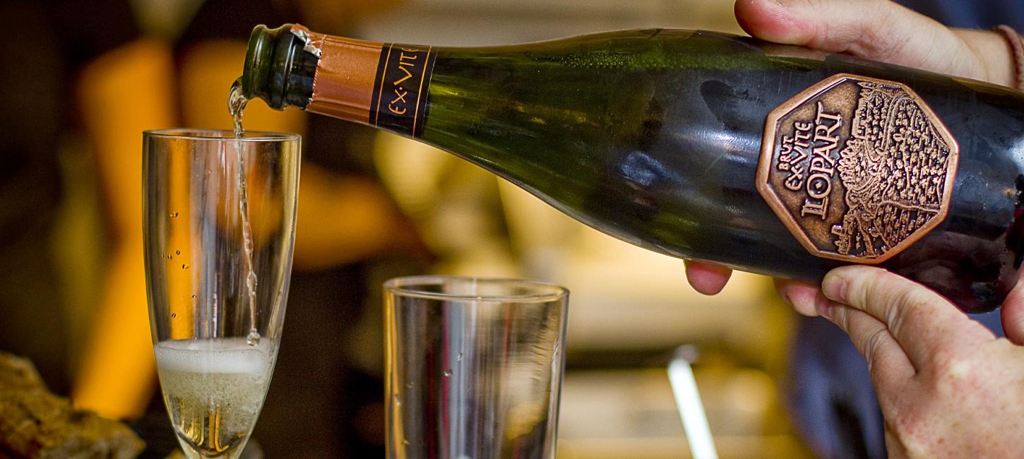 Champagne hældes i glas på stilk