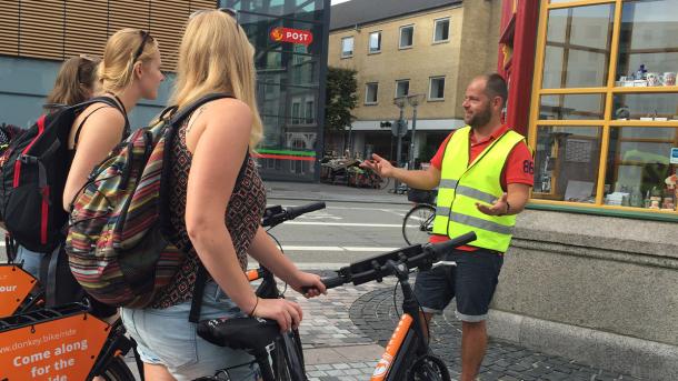 Gruppe med cykler får guided tur på Gabels Torv i Aalborg