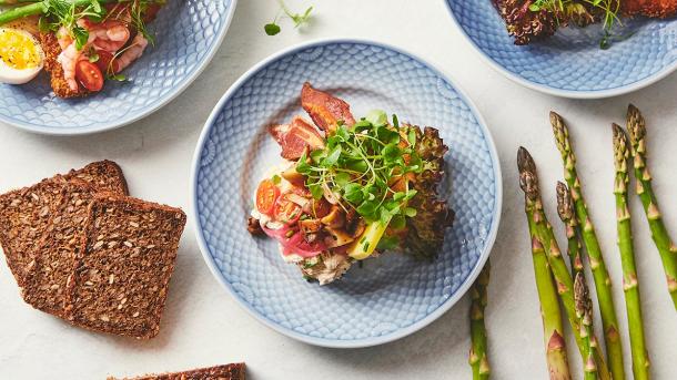 Smørrebrød fra den bette kro, omringet af rugbrød og asparges