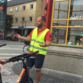 Gruppe med cykler får guided tur på Gabels Torv i Aalborg