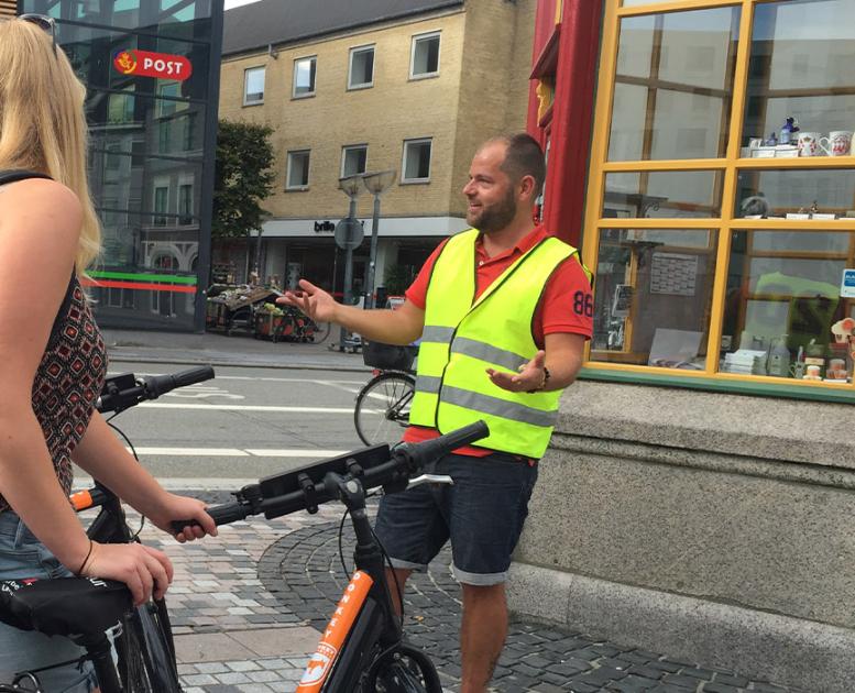 Gruppe med cykler får guided tur på Gabels Torv i Aalborg